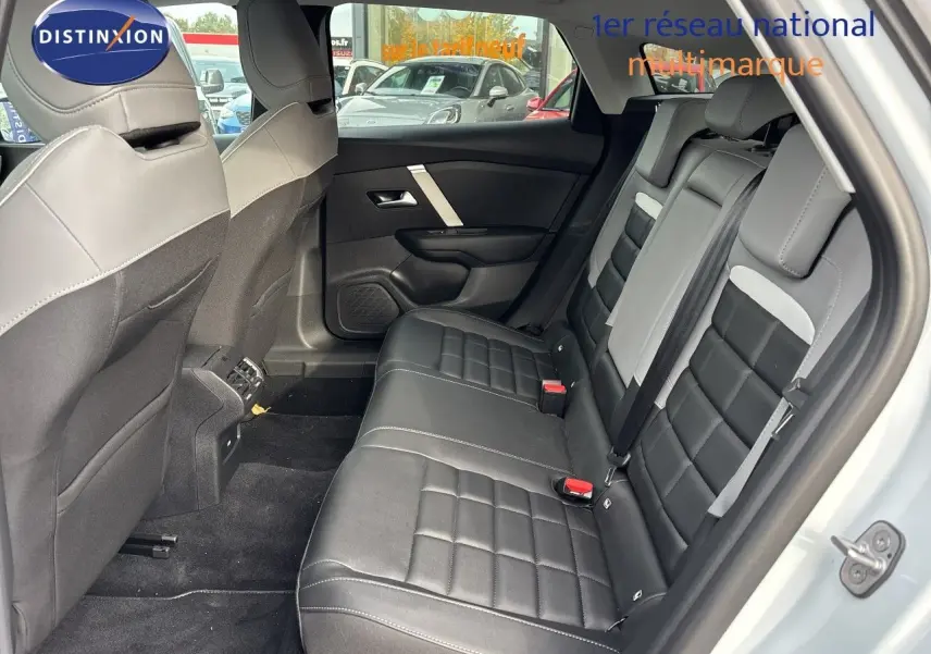 Vue intérieure côté droit des sièges arrière en cuir noir avec surpiqûres blanches de la Citroën C4 Hybrid 2025 blanc Okenite Metal.