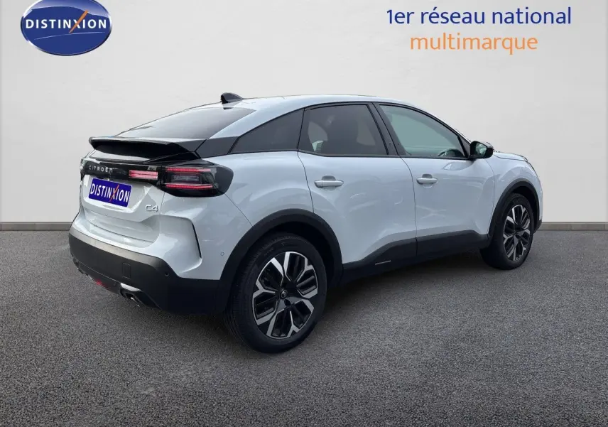 Vue 3/4 arrière droite d'une Citroën C4 Hybrid 145ch blanche Okenite métallisée avec toit noir et jantes bi-ton.
