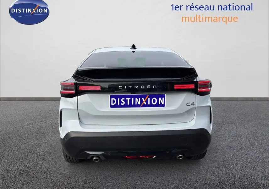 Vue arrière d'une Citroën C4 blanche Okenite Metal avec bande noire brillante et feux arrière LED horizontaux.