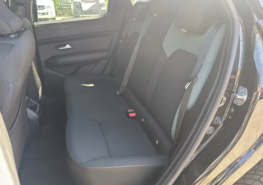 Vue intérieure côté droit sur la banquette arrière noire du Dacia Duster Hybrid-G 150 4x4 Extreme City 2026.