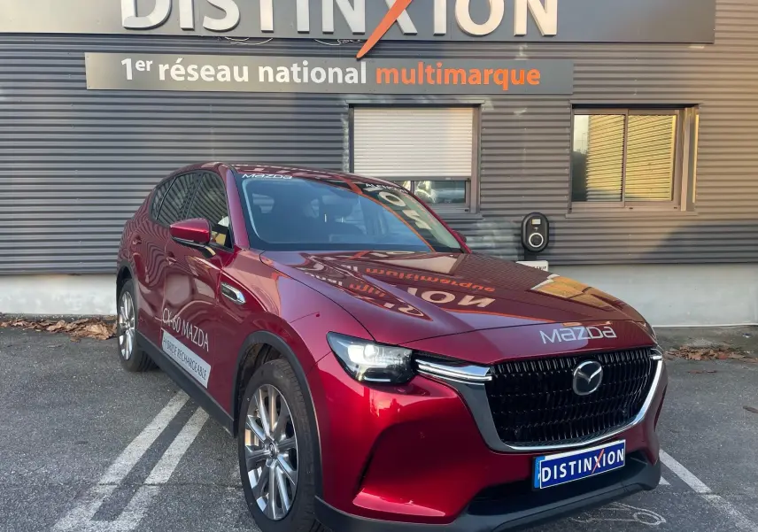 Vue 3/4 avant gauche d'un Mazda CX-60 Soul Red Crystal hybride rechargeable avec calandre noire et jantes argentées.