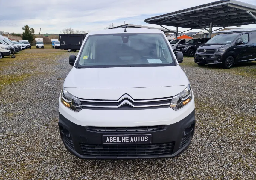 Vue frontale d’un Citroën Berlingo blanc 2021 avec calandre noire et plaque Abeilhe Autos sur un parking extérieur.