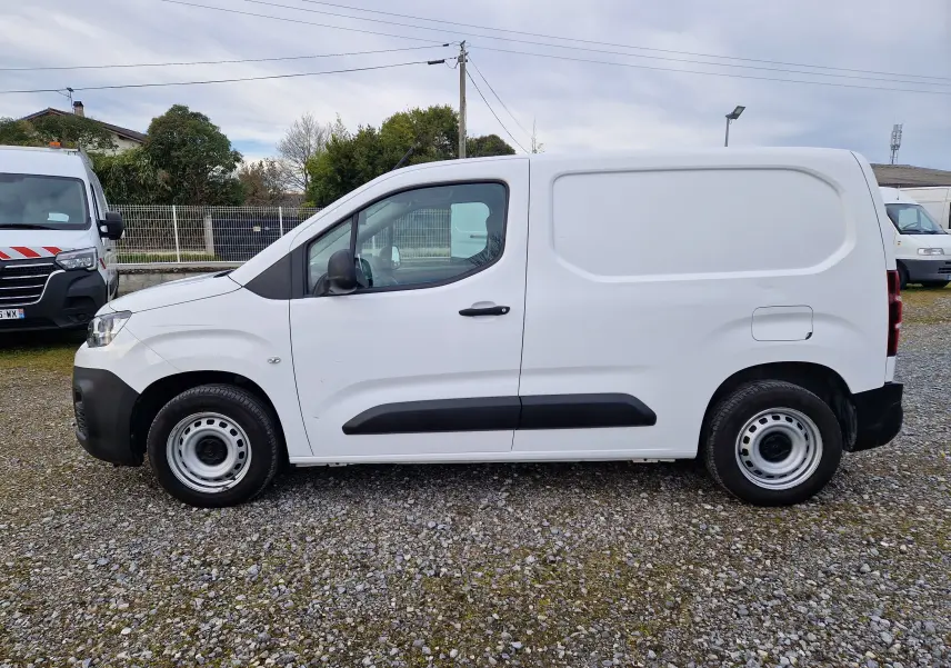 Vue latérale droite d'un utilitaire Citroën Berlingo blanc 2021 avec porte latérale coulissante et protections noires.