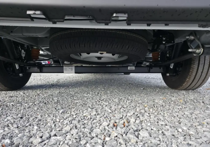 Vue en contre-plongée sous un Fiat Ducato Fourgon blanc, montrant la roue de secours et le châssis arrière.