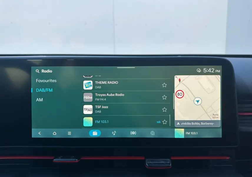 Écran tactile multimédia 12,3'' du Hyundai Kona 2026 en gros plan avec interface radio et navigation visible.