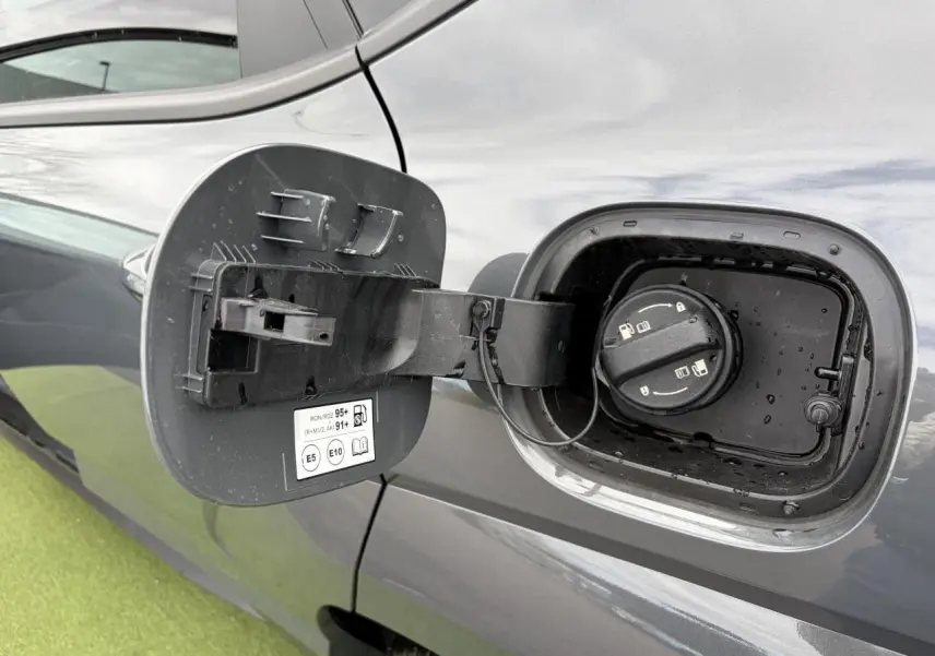 Vue rapprochée de la trappe à carburant ouverte côté gauche d’un Hyundai Kona 2026 gris métallisé.