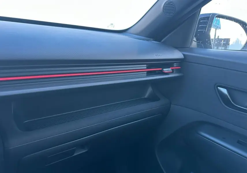 Vue intérieure côté passager du tableau de bord noir avec bande LED rouge du Hyundai Kona 2026 finition N Line.