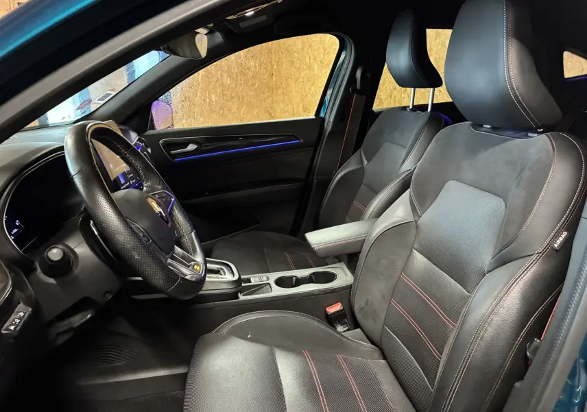 Gros plan sur la porte côté conducteur du Renault Arkana bleu, avec surpiqûres rouges et commandes de vitres.