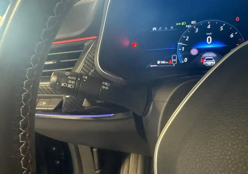 Tableau de bord numérique bleu et noir du Renault Arkana 1.3 TCE 140 RS-LINE, avec commandes et éclairage d'ambiance violet.