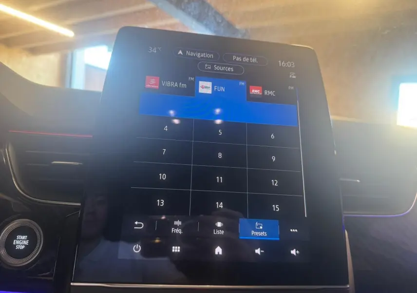 Écran tactile central affichant les stations radio, intérieur noir avec éclairage d'ambiance violet du Renault Arkana 2021.