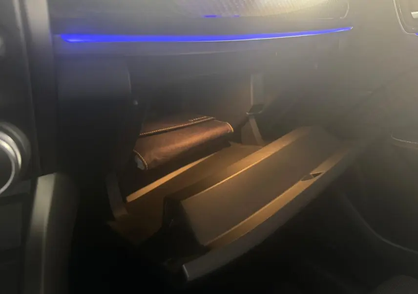 Vue intérieure du coffre à gants ouvert avec éclairage bleu, dans une Renault Arkana 1.3 TCE 140 RS-LINE 2021 bleu.