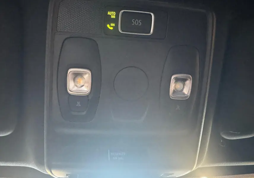 Vue rapprochée du plafonnier intérieur avec bouton SOS illuminé dans un Renault Arkana bleu 2021.