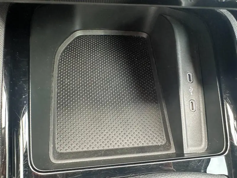 Gros plan sur la console centrale noire du Skoda Scala blanc, avec zone de rangement et ports USB visibles.