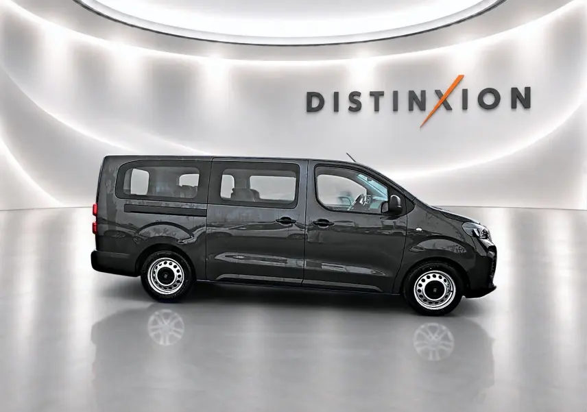 Vue de profil côté gauche d’un FIAT Scudo Combi gris titane avec porte latérale coulissante, sur fond blanc lumineux.