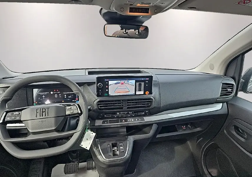 Vue intérieure avant du Fiat Scudo Combi gris titane 2026, tableau de bord moderne avec écran tactile et volant multifonction.