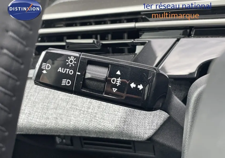 Gros plan sur la commande des feux et clignotants du Peugeot 3008 Hybrid 2025, intérieur gris et noir.