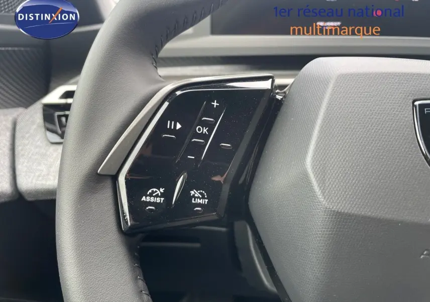 Gros plan sur les commandes à gauche du volant noir du Peugeot 3008 Hybrid 2025, soulignant les fonctions assist et limitateur.