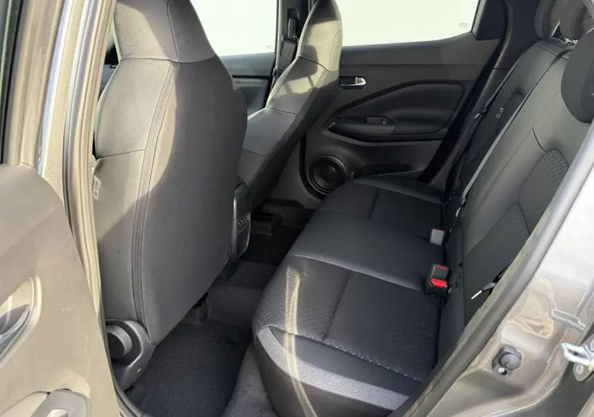 Vue intérieure côté droit sur la banquette arrière noire en tissu et TEP du Nissan Juke II 1.6 Hybrid 2025.