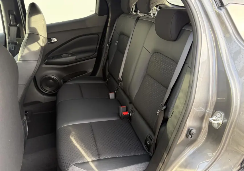 Vue intérieure côté droit de la banquette arrière noire avec ceintures grises du Nissan Juke II 1.6 Hybrid 2025.