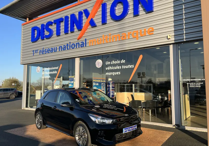 KIA Rio 1.0 GDI 100 Hybrid GT Line noire vue en 3/4 avant droit devant un showroom Distinxion.