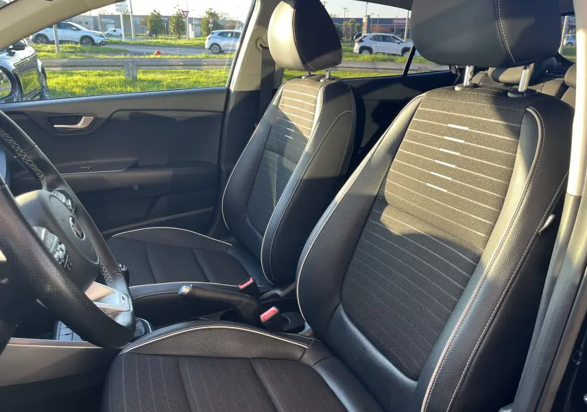 Vue intérieure de face des sièges avant en tissu et cuir noir de la KIA RIO 1.0 GDI 100 HYBRID GT LINE 2021.
