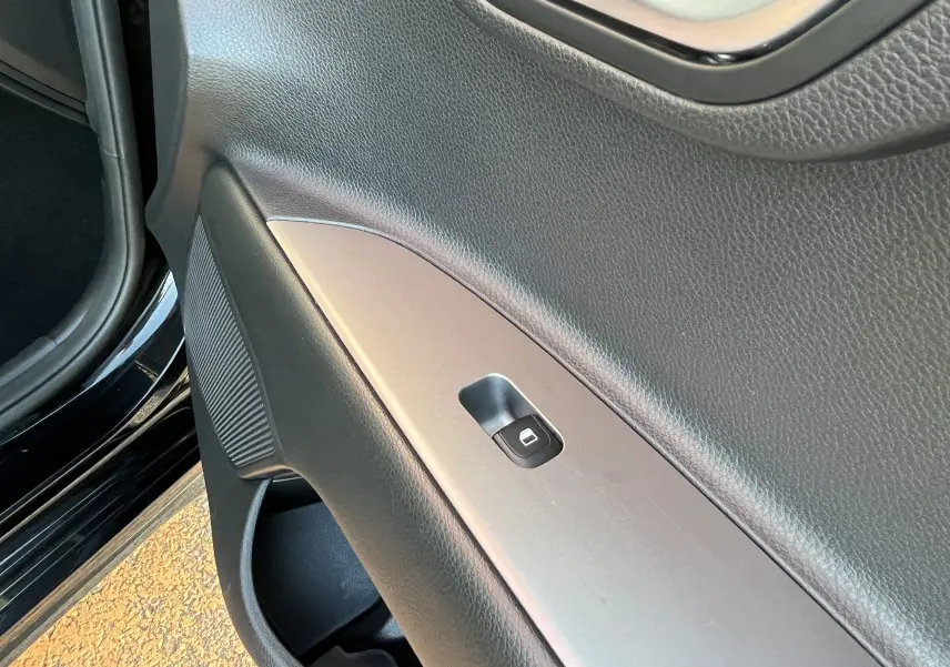 Détail de la porte côté conducteur de la KIA Rio noire 2021, avec bouton de verrouillage centralisé visible.