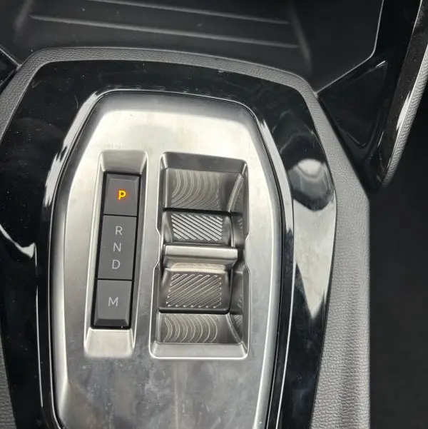 Gros plan sur la console centrale de la Peugeot 208 Hybrid 100 e-DCS6 Style 2025, montrant la commande de boîte automatique gris métallisé.