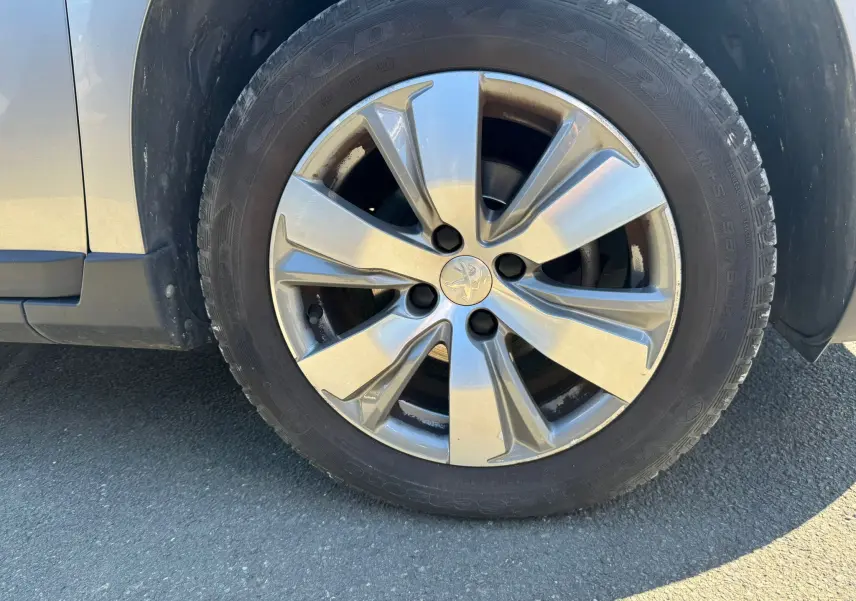 Gros plan sur la roue avant gauche gris métallisé du Peugeot 2008 1.6 HDI 100 STYLE de 2016 avec jante alliage.