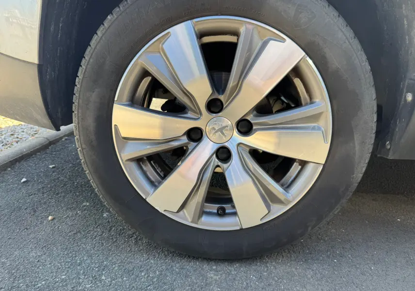 Gros plan sur la jante alliage argentée du côté gauche d’un Peugeot 2008 gris diesel de 2016.