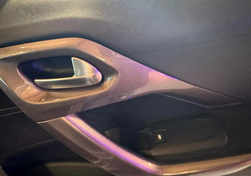 Poignée intérieure de porte côté gauche du Peugeot 2008 gris, finition STYLE, avec insert plastique brillant.