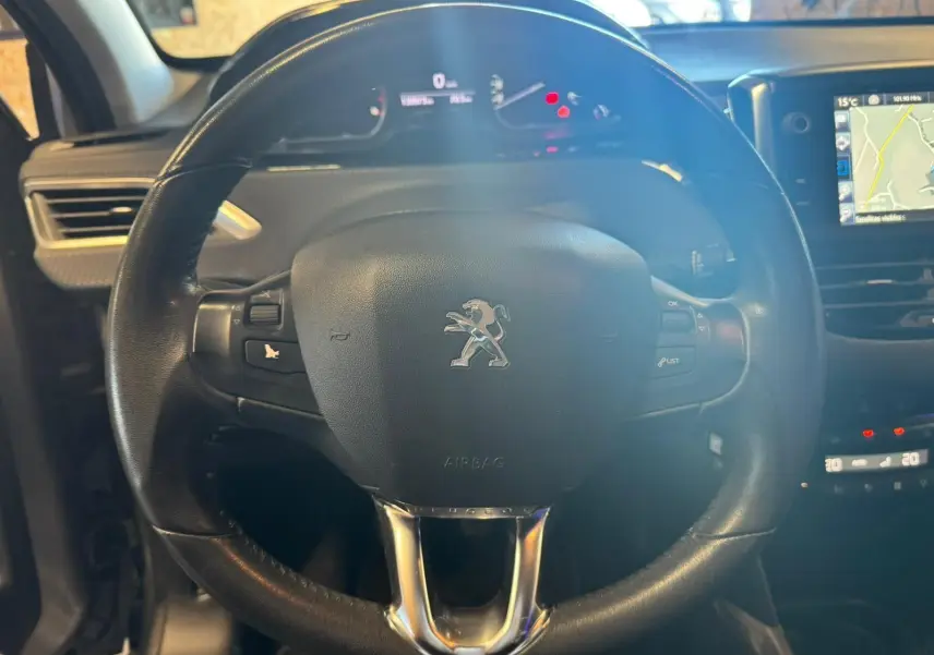 Vue rapprochée du volant noir de la Peugeot 2008 1.6 HDI 2016 avec tableau de bord et écran GPS visible.