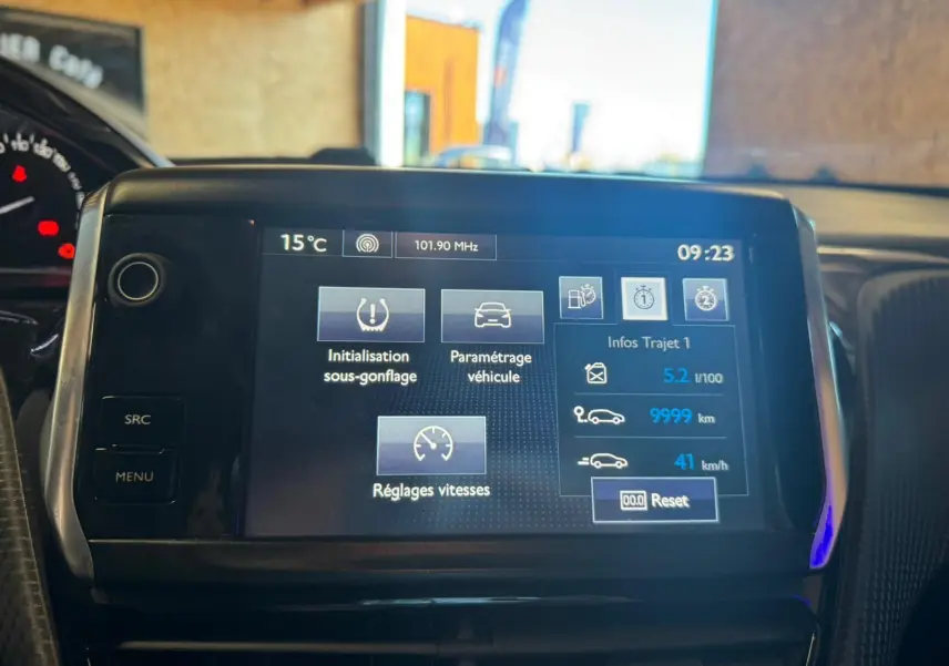 Écran tactile central du tableau de bord du Peugeot 2008 gris, affichant les réglages et infos trajet.