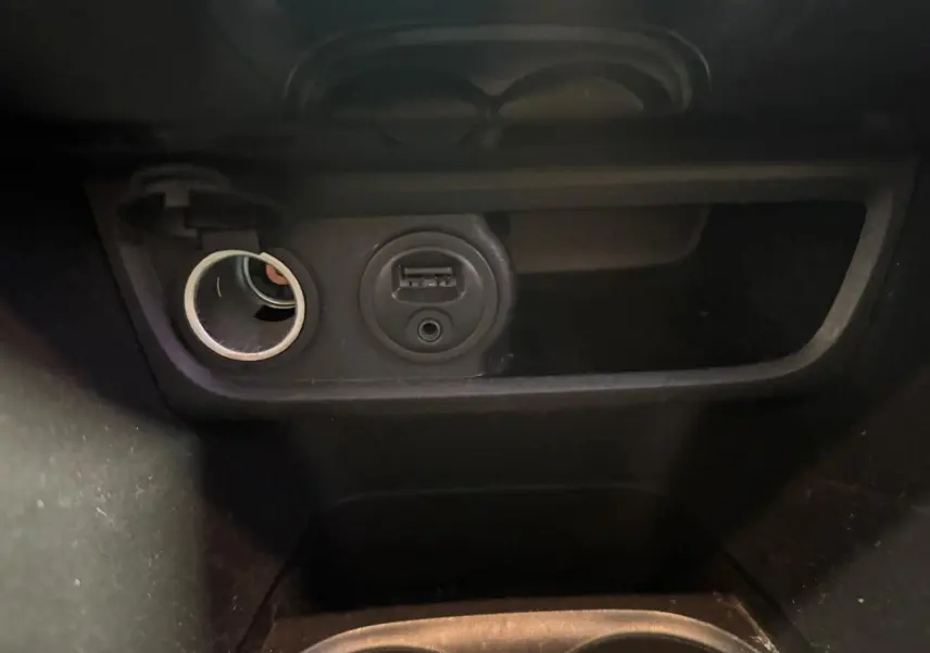 Prise allume-cigare et port USB en gros plan dans l’habitacle noir du Peugeot 2008 1.6 HDI 2016.