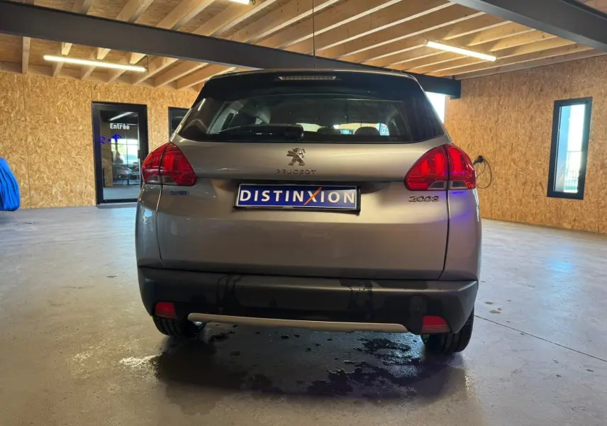 Vue arrière d’un Peugeot 2008 gris 2016 dans un garage avec plaque Distinxion visible.