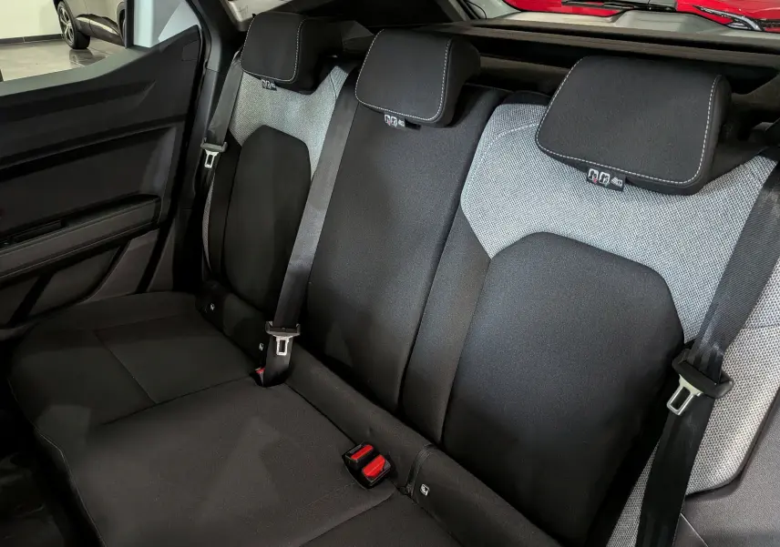 Vue intérieure montrant la banquette arrière noire et grise du Dacia Duster Hybrid-G 150 CH 4x4 Journey 2026.