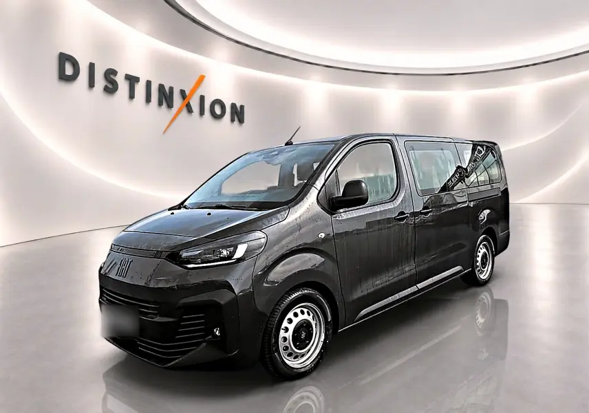 Fiat Scudo Combi gris titane en 3/4 avant droit, porte latérale coulissante visible, sur fond clair intérieur showroom.