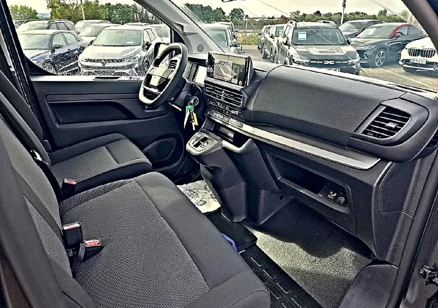 Vue intérieure côté conducteur du Fiat Scudo Combi 2026, montrant sièges bi-ton noirs et tableau de bord moderne avec écran tactile.