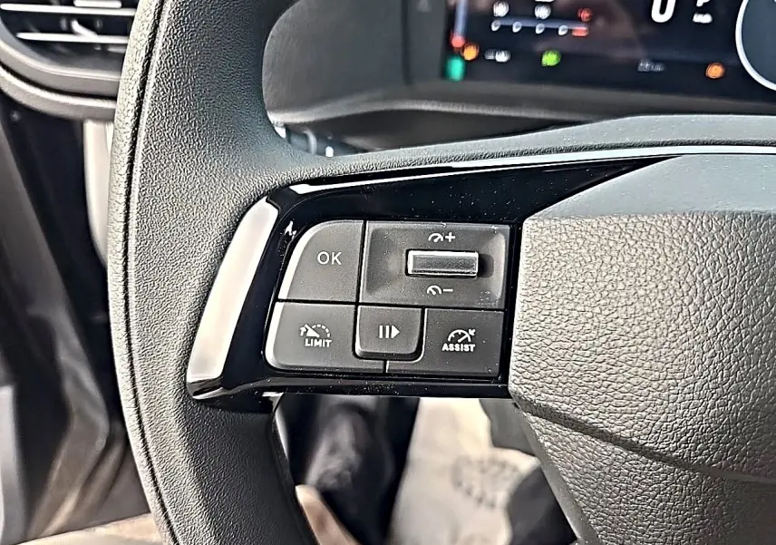 Gros plan sur les commandes noires au volant du Fiat Scudo Combi gris titane, avec affichage numérique en arrière-plan.