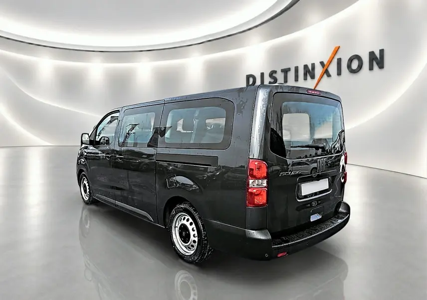 Vue 3/4 arrière droite d'un FIAT Scudo Combi gris titane avec porte latérale coulissante dans un showroom lumineux.
