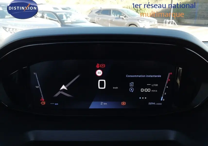 Vue de face du tableau de bord numérique du Peugeot Partner blanc Kaolin 2026, affichant la consommation instantanée et la vitesse à 0 km/h.