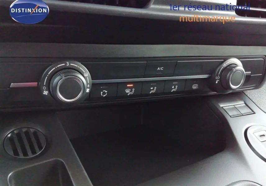 Détail de la console centrale avec commandes de climatisation du Peugeot Partner blanc Kaolin, vue intérieure rapprochée.