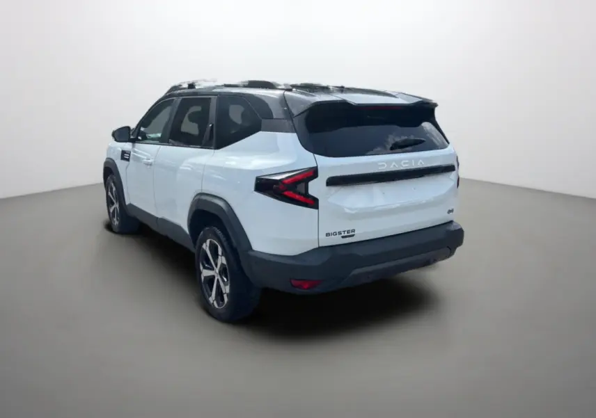 Vue 3/4 arrière droite du Dacia Bigster blanc à toit noir avec jantes alu 18 pouces et vitres surteintées.