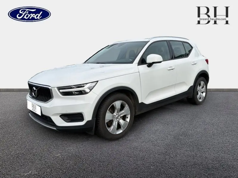 Vue 3/4 avant droite d'un Volvo XC40 blanc Glace avec jantes alliage et calandre noire distinctive.