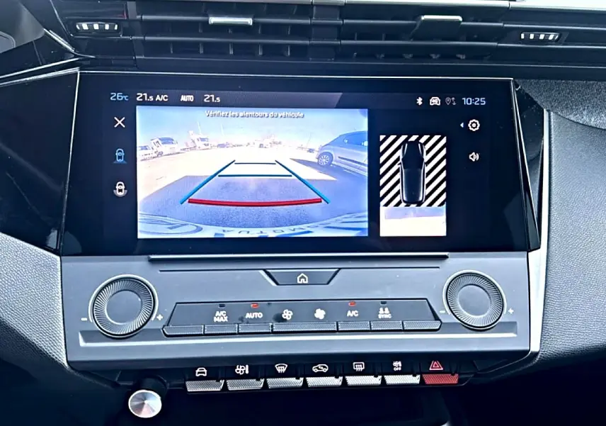 Écran tactile central de la Peugeot 308 2025 gris selenium montrant la caméra de recul et les commandes climatisation.