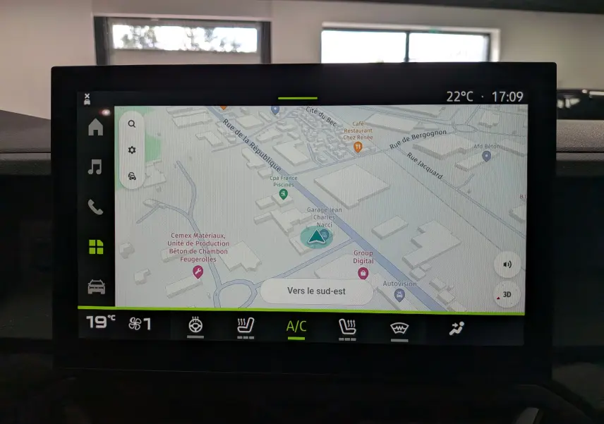 Écran tactile central du Dacia Duster Hybrid-G 150 CH 4x4 blanc, affichant la navigation GPS et les commandes climatisation.