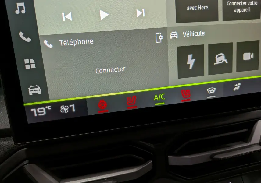Écran tactile du tableau de bord du Dacia Duster Hybrid-G 150 CH 4x4, affichant les commandes de climatisation et connectivité.