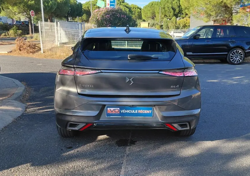 Vue arrière d'une DS4 Hybride E-Tense gris métallisé, avec feux LED effilés et double sortie d'échappement intégrée.