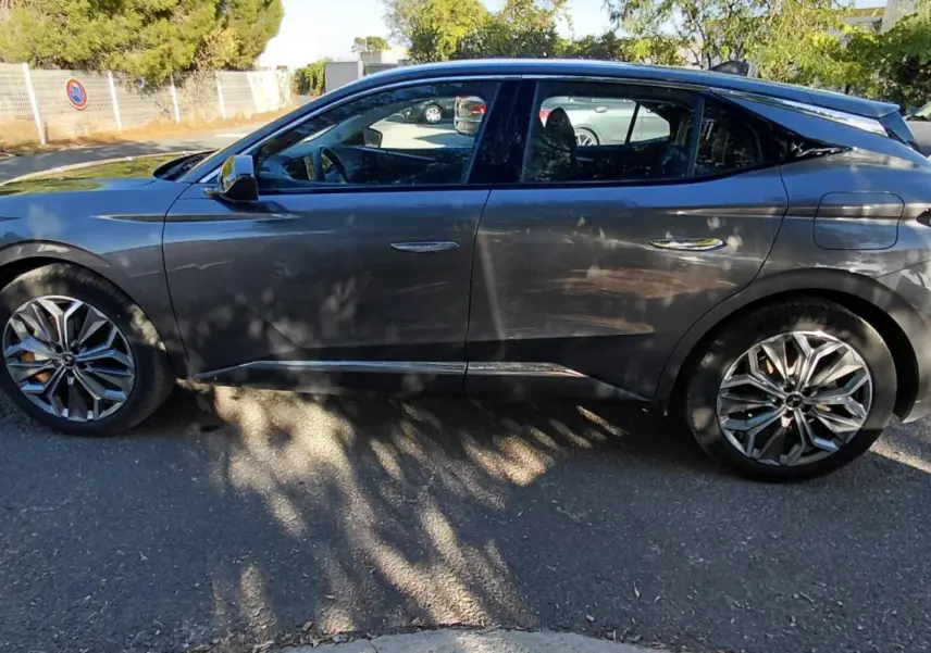 Vue latérale côté gauche d'une DS4 hybride E-Tense 225 gris métallisé avec jantes alliage 19 pouces, en extérieur.