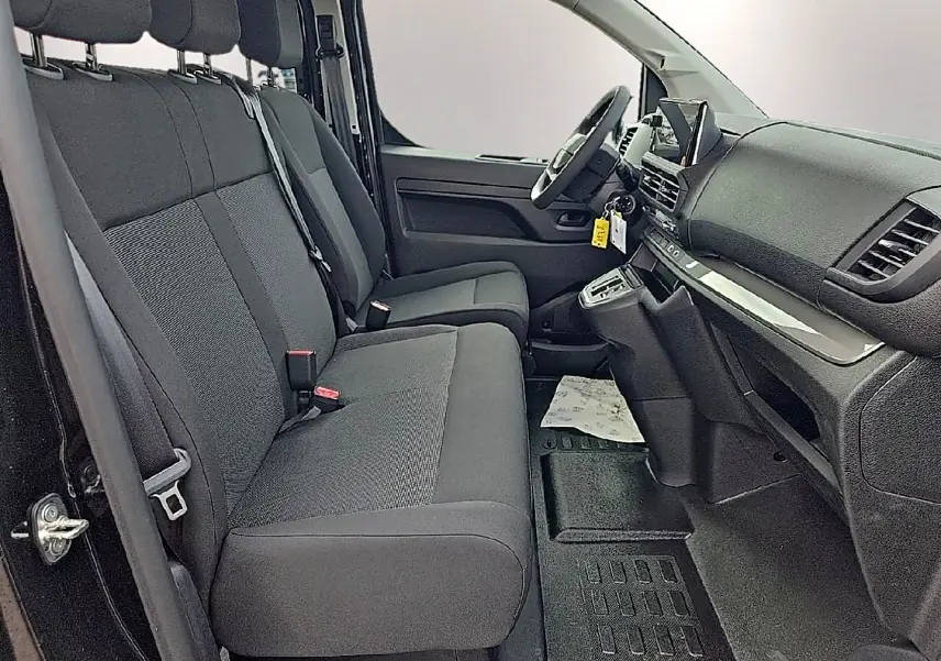 Vue intérieure côté conducteur du Fiat Scudo Combi 2026, sièges bi-ton gris et tableau de bord noir avec écran tactile.