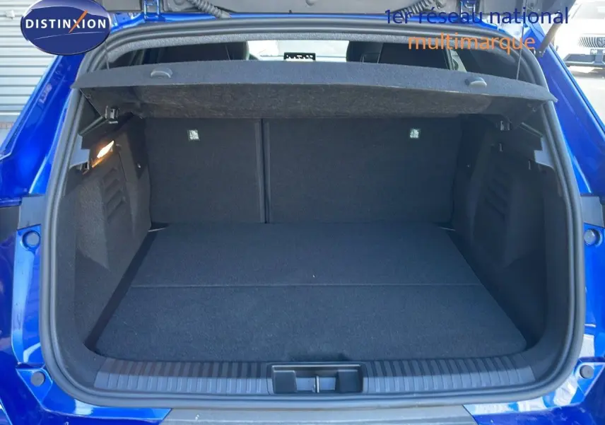 Coffre ouvert vu de l'arrière du Renault SYMBIOZ bleu iron metal, montrant un espace de chargement spacieux et propre.